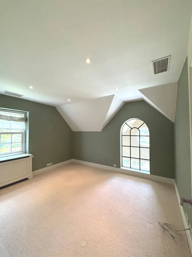 Chambre sous combles à la fenêtre cintrée